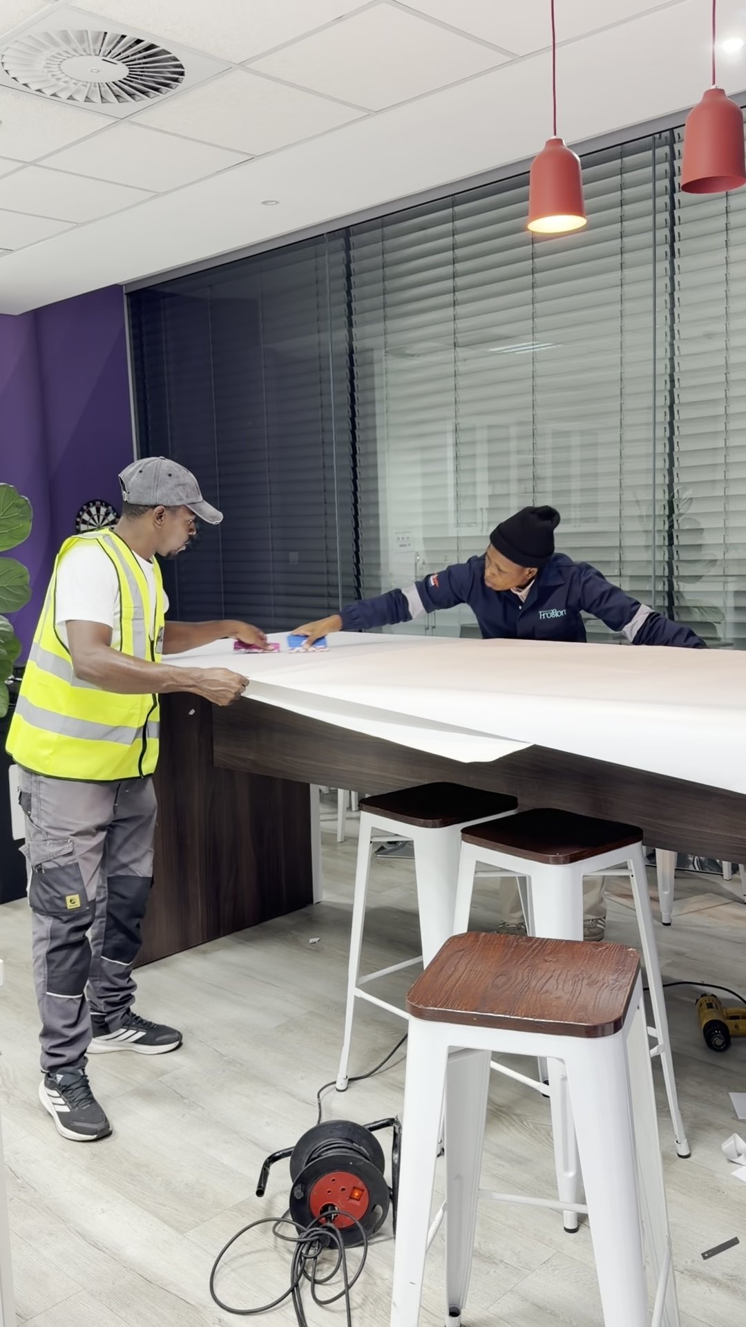 SurfaceOn team wrapping a boardroom table in place